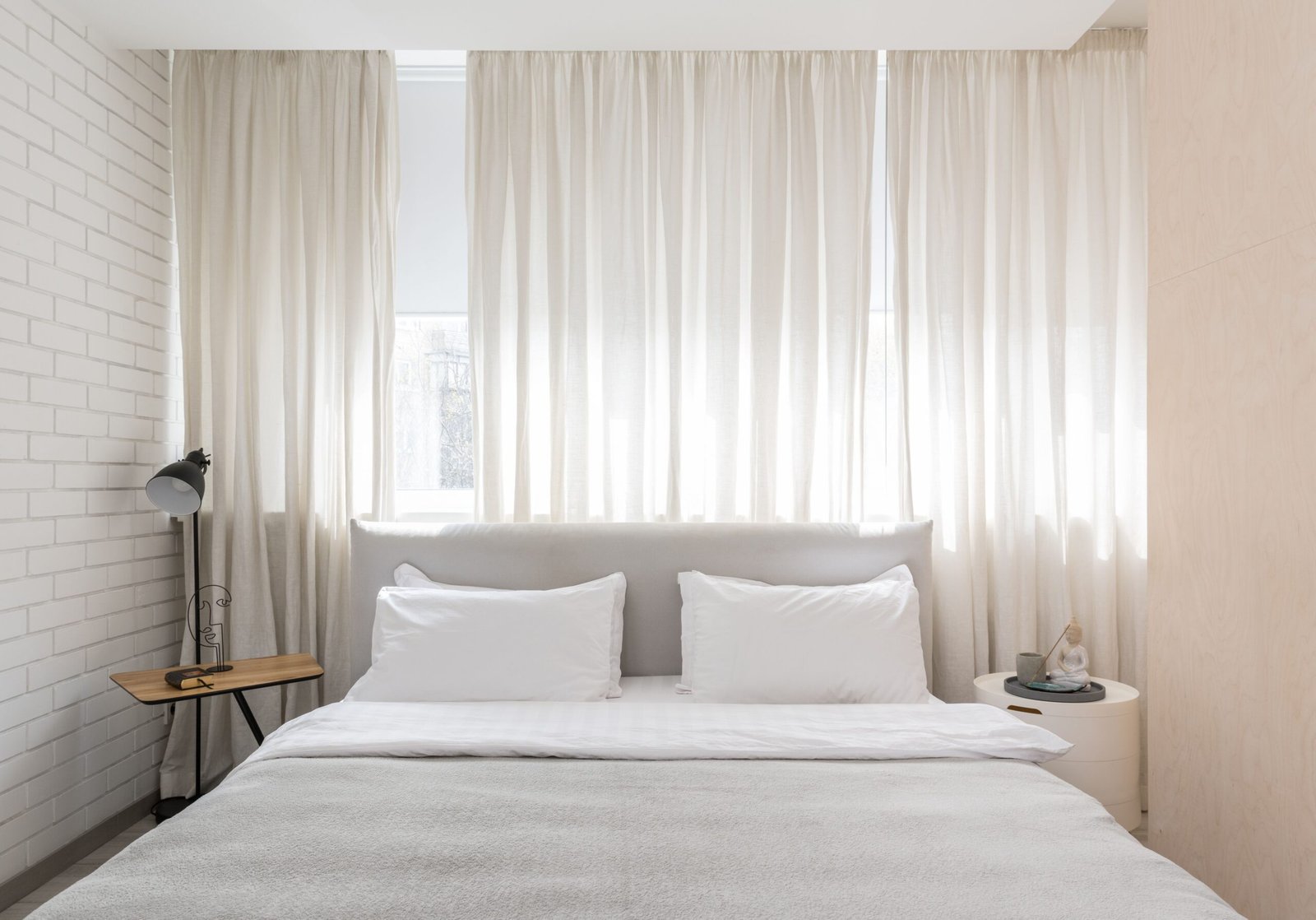 Bed with light furniture and calm decor